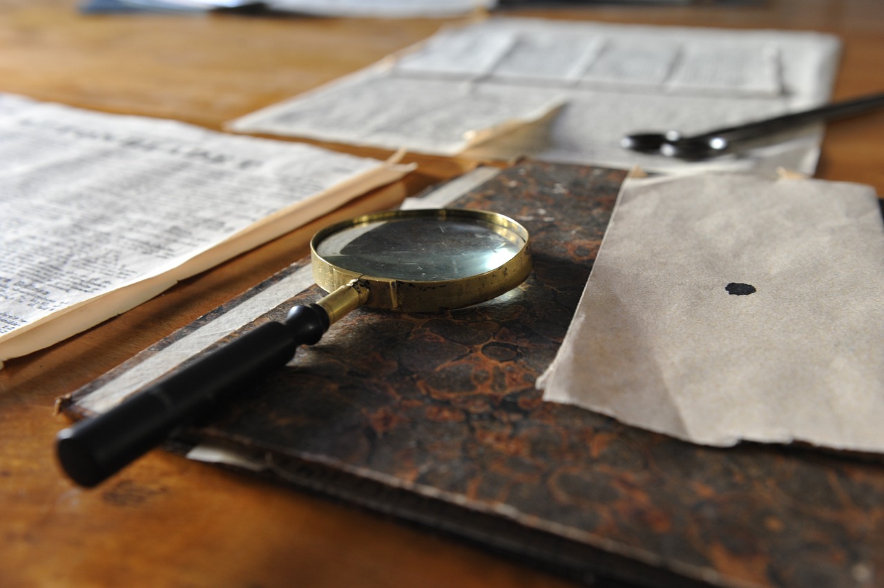 Newspaper, book and magnifying glass on the table